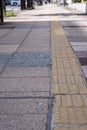 Bright yellow tactile footpath for people who have visually impaired on the walkway.