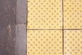 Bright yellow tactile paving for the visually impaired on the sidewalk