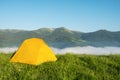 Bright yellow tourist tent in the mountains nature