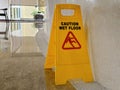 Bright yellow triangular \'Caution Wet Floor\' sign standing upright Royalty Free Stock Photo