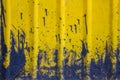 Bright yellow wavy plastic wall with blue splashes and spots of paint. rough surface texture Royalty Free Stock Photo