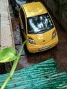 Bright Yelow TATA Nano car parked tight in small parking space in campound ghatkoper