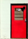 Brightl red, painted door on a white birck building Royalty Free Stock Photo