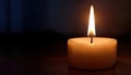 brightly burning candle in dimly lit room symbolizes hope and determination Royalty Free Stock Photo