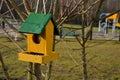 a brightly colored bird feeder on the edge of the playground is