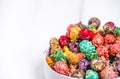 Brightly Colored Candied Popcorn, white background. Horizontal image of Junk food, fruit flavored popcorn in light pink bowl. Colo