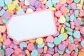 Brightly colored candy hearts, white card with pink border