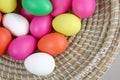Brightly coloured easter eggs, in a straw basket against a grey background Royalty Free Stock Photo