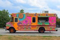 A brightly colored food truck parked in a busy parking lot, serving delicious meals to customers, Indian food truck with bright
