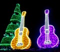 Brightly Colored Guitars and and Holiday Tree lit up with Lights Royalty Free Stock Photo
