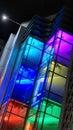 Brightly colored illuminated glass facade of house at night