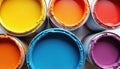 Brightly colored open paint cans with various vibrant hues like yellow, orange, red, blue, purple. Artistic interior design Royalty Free Stock Photo