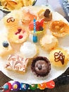 Brightly colored plate of birthday cupcakes with a candle in the middle