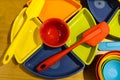 Brightly colored serving dishes and plasticware - top view on wooden surface