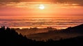 Brightly colored sunset in the Santa Cruz mountains, layered hills and valleys visible in the foreground and sea of clouds in the Royalty Free Stock Photo
