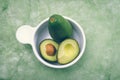 Brightly colored two avocados in a white bowl with Royalty Free Stock Photo