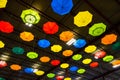 Brightly colored umbrellas hanging from metal ceiling of warehouse space Royalty Free Stock Photo