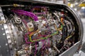 Brightly colored wires and metallic parts are visible on the engine of an aircraft in a workshop. This close-up captures the Royalty Free Stock Photo