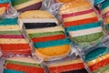 Brightly coloured favored cheese wrapped for sale at a market