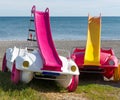 Brightly coloured pedalos with slides. Royalty Free Stock Photo