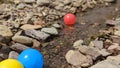Brightly Coloured plastic balls floating down the stream on the river