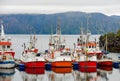 Colourful fishing trawlers, misty mountains, calm waters in a Norwegian fishing village Royalty Free Stock Photo