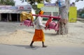 Brightly dressed religious pilgrims walk alongside the road in rural India.