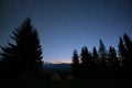 Brightly illuminated camping tents glowing on campsite in dark mountains under night stars covered sky. Active lifestyle Royalty Free Stock Photo