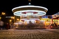 Brightly illuminated traditional carousel at night city festival