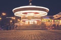 Brightly illuminated traditional carousel at night city festival