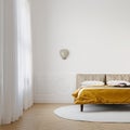 Brightly lit bedroom with vibrant gold color bedspread, mock-up with negative space