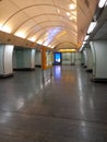 Brightly lit empty underground subway station in perspective. Arched ceiling and information board