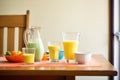 brightly lit table with a pitcher and glasses filled with mango lassi Royalty Free Stock Photo