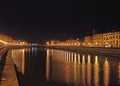 Brightly Lit Waterfront At River Arno In The Old Town Of Pisa Italy At Night