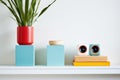 brightly painted wooden speakers on a minimalist white shelf