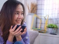 Brightly smiling Asian women enjoyed drink coffee in the morning. Woman holding a coffee cup and looking out the window in the bed Royalty Free Stock Photo