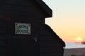 Brighton beach hut sunset with old pier Royalty Free Stock Photo