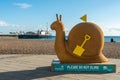 Brighton, England-18 October,2018: Giant snail trail on the Brighton Pier Beach with brighton pier amusements in the background at