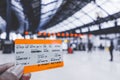 Hand holding a UK train ticket at Brighton & Hove train station for background in Brighton, England.