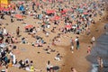 Crowd of British people sunbathing swimming and relaxing in the beach at summer. Leisure time outdoor