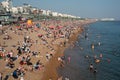 Crowd of British people sunbathing swimming and relaxing in the beach at summer. Leisure time outdoor