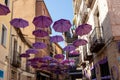 BRIHUEGA, SPAIN - JULY 10, 2021: Lavender colored umbrellas at the street during fields blooming period, Brihuega,Guadalajara,