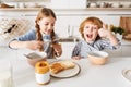 Brilliant bright siblings having fun during breakfast Royalty Free Stock Photo