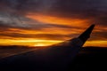 Brilliant colorful sunset behind jet plane wing from sky copy Royalty Free Stock Photo