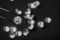 Brilliant cut diamond held by tweezers on black background Royalty Free Stock Photo