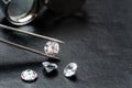 Brilliant cut diamond held by tweezers on black background Royalty Free Stock Photo