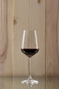 Brilliant glass with red wine on a wooden background on a glass stand