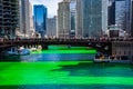 Brilliant green dyed Chicago River is surrounded by celebrating crowd of people