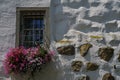 Natural stone wall with old window and floral decoration