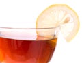 Brim of transparent cup with tea and lemon